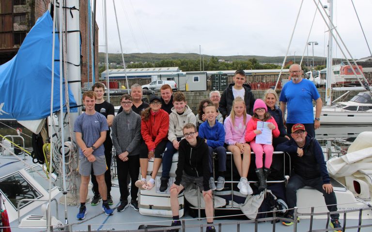 Young people pose on the deck of Alba Venturer with group leaders, volunteers and sea staff